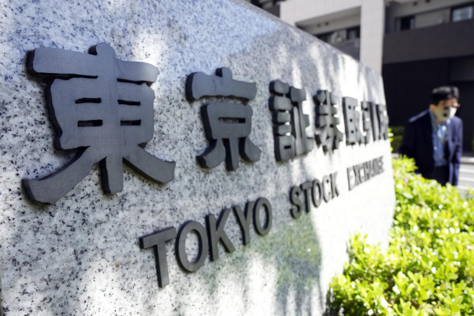 A person walks near the sign of the Tokyo Stock Exchange Thursday, April 27, 2023, in Tokyo. Asian stock markets were mixed Friday after Wall Street sank on worries about the health of U.S. banks that are under pressure from interest rate hikes. (AP Photo/Eugene Hoshiko)