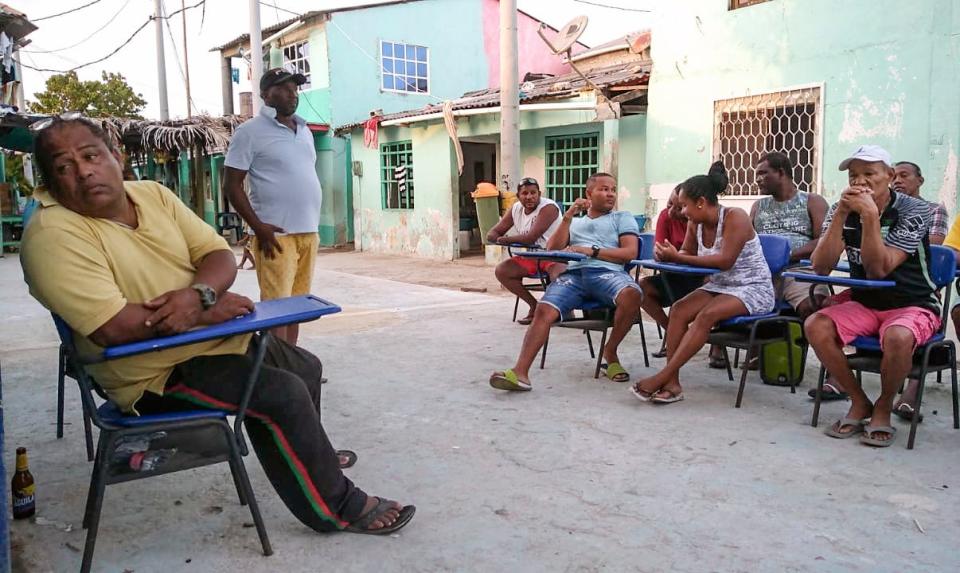 Locals sit in a street at Santa Cruz del Islote island, located in the Colombian Caribbean, off the coast of Sucre Department, on June 17, 2020.