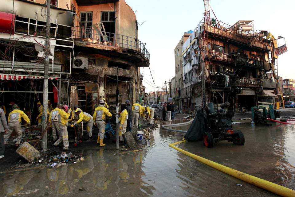 Baghdad municipality workers clean at the site of a car bomb attack in Baghdad, Iraq, Tuesday, Feb. 18, 2014. A wave of explosions rocked mainly Shiite neighborhoods in Baghdad shortly after sunset on Monday, killing and wounding scores of people, said Iraqi officials. (AP Photo/Hadi Mizban)