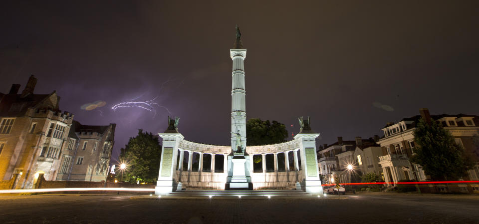 FILE - In this July 17, 2017 file photo, lightening streaks across the sky behind a statue honoring Confederate President Jefferson Davis on Monument Avenue in Richmond, Va. Virginia Democrats seized control of the General Assembly last week and that means Confederate statues could soon be coming down in a state that's full of them. (AP Photo/Steve Helber, File)