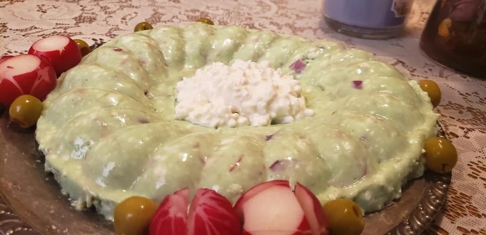 a green gelatinized mixture in the shape of a ring with cottage cheese in the middle