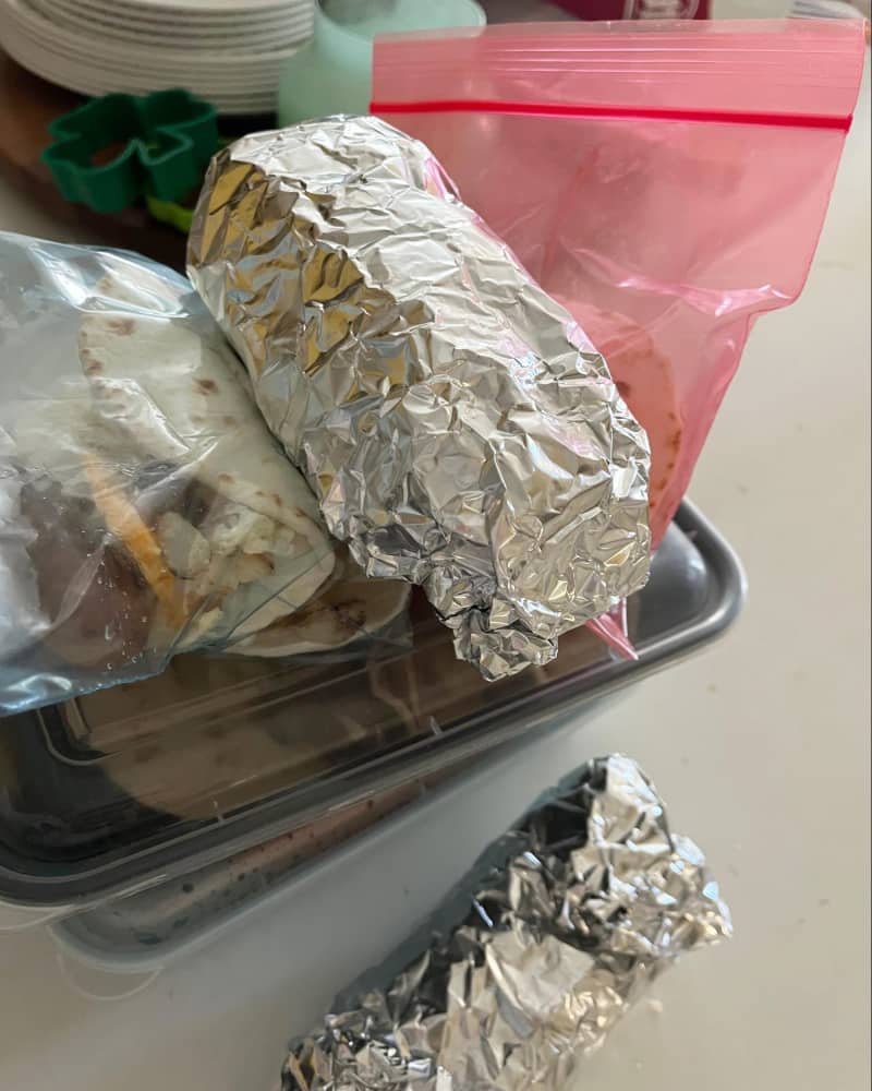 2 breakfast burritos wrapped in tinfoil
