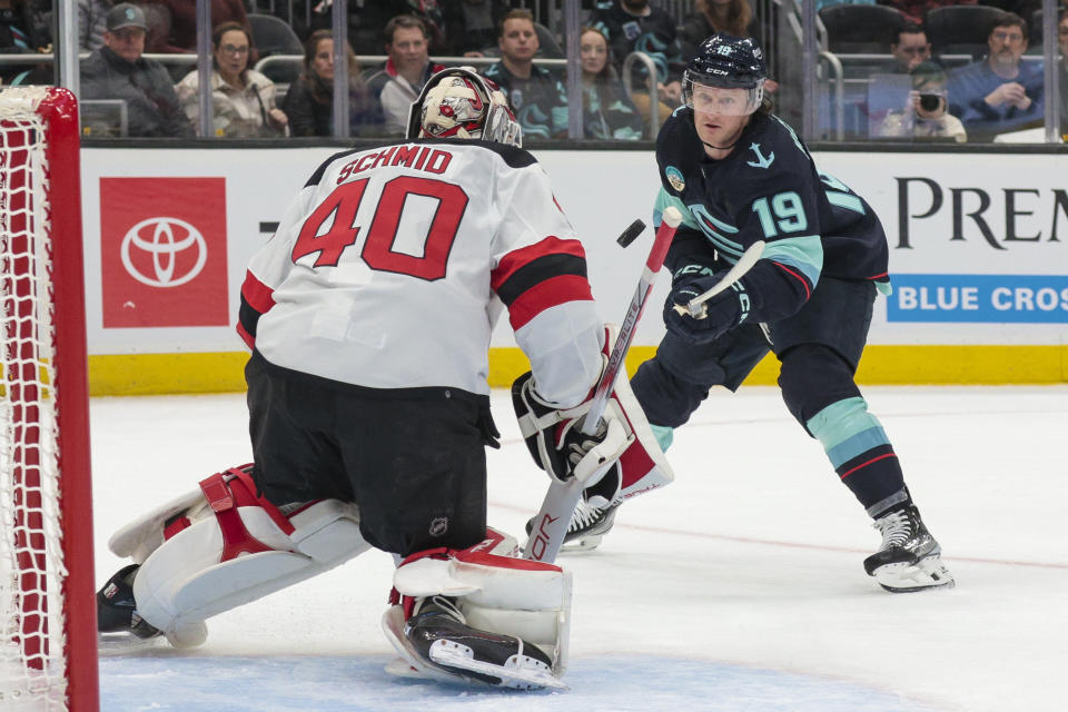 Seattle Kraken left wing Jared McCann (19) shoots the puck on New Jersey Devils goaltender Akira Schmid, who stopped the shot during the first period of an NHL hockey game Thursday, Dec. 7, 2023, in Seattle. (AP Photo/Jason Redmond)