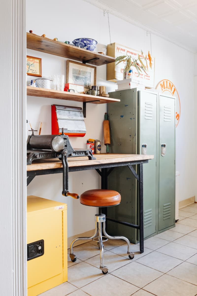 Lockers flank wood work table in white room.