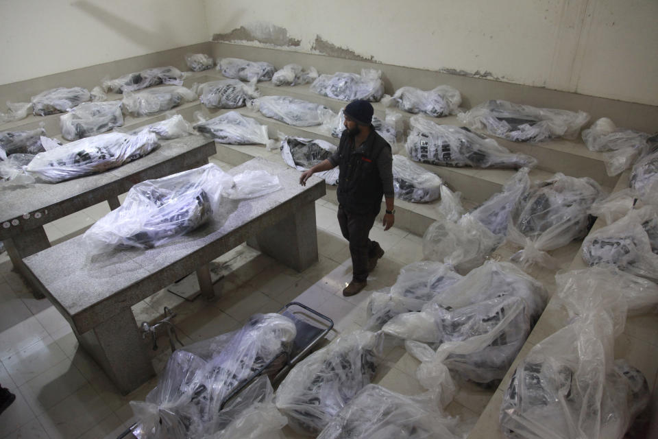 A hospital worker stand beside the bodied, who were killed in the bus accident, at a morgue, in Karachi, Pakistan, Sunday, Jan. 29, 2023. The passenger bus crashed into a pillar and fell off a bridge, catching fire and killing dozens of people in southern Pakistan on Sunday, a government official said. (AP Photo/Ikram Suri)