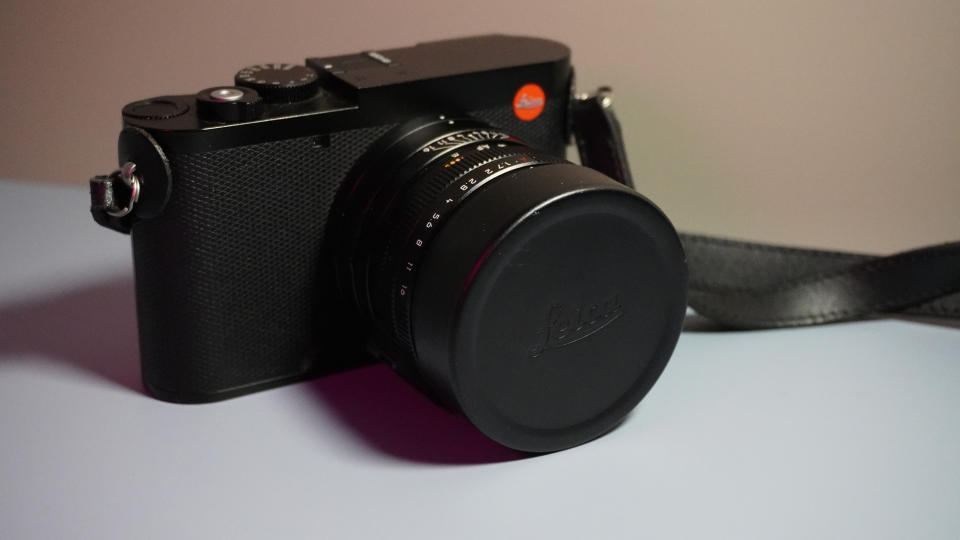 The Leica Q3 camera on a grey and pink background