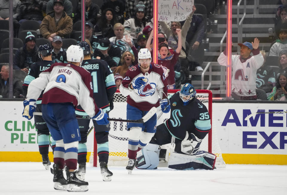 Colorado Avalanche right wing Valeri Nichushkin (13) looks back to point at teammate Cale Makar (8) after scoring a goal as Seattle Kraken goaltender Joey Daccord (35) looks down during the third period of an NHL hockey game, Monday, Nov. 13, 2023, in Seattle. (AP Photo/Lindsey Wasson)