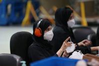 Workers sort through N95 masks, made at the Strata Manufacturing facility, in Al Ain