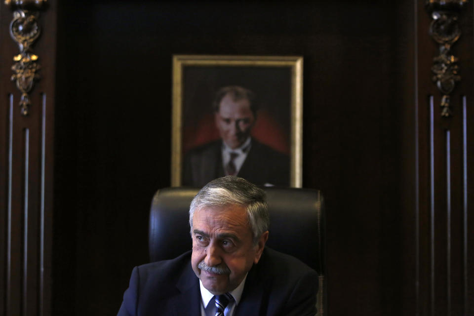 FILE - In this Monday, April 4, 2016 file photo, Turkish Cypriot leader Mustafa Akinci is seen at his office in front of the portrait of the Turkish Republic founder Kemal Ataturk, during an interview for the Associated Press in the Turkish breakaway north part of the divided capital Nicosia in this ethnically Mediterranean island of Cyprus. Turkish Cypriots vote on Sunday Oct. 18, 2020 in a leadership runoff that could decide if they want to retain more control over their own affairs or steer even closer to an increasingly domineering Turkey. (AP Photo/Petros Karadjias, File)