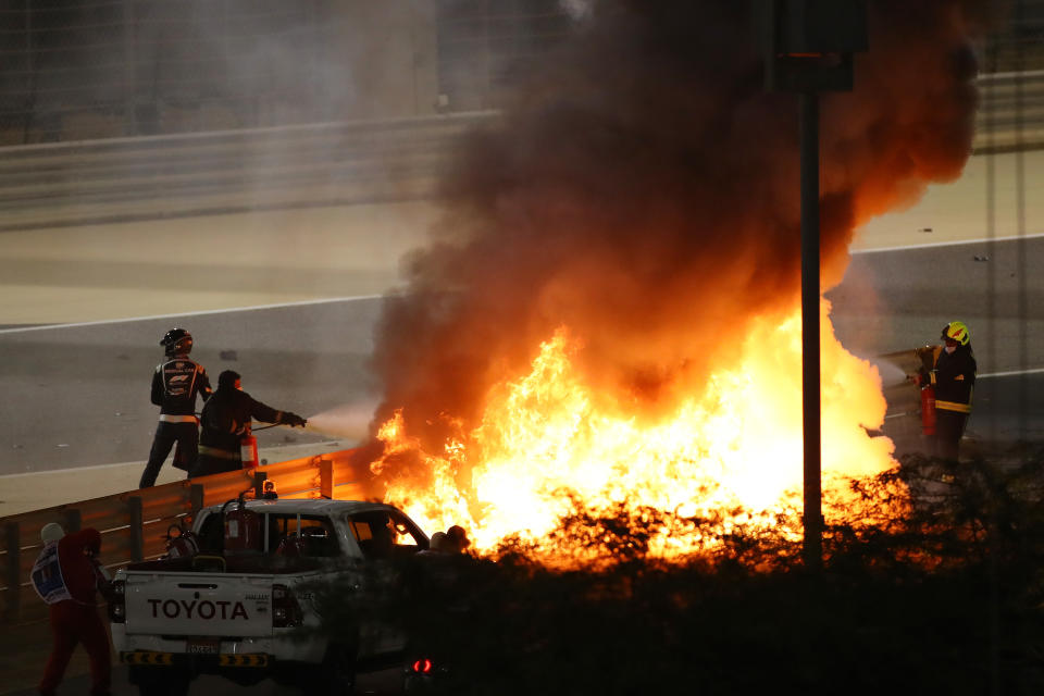 Officials are pictured here putting out a fire from Romain Grosjean's Haas at the 2020 Bahrain Grand Prix. 