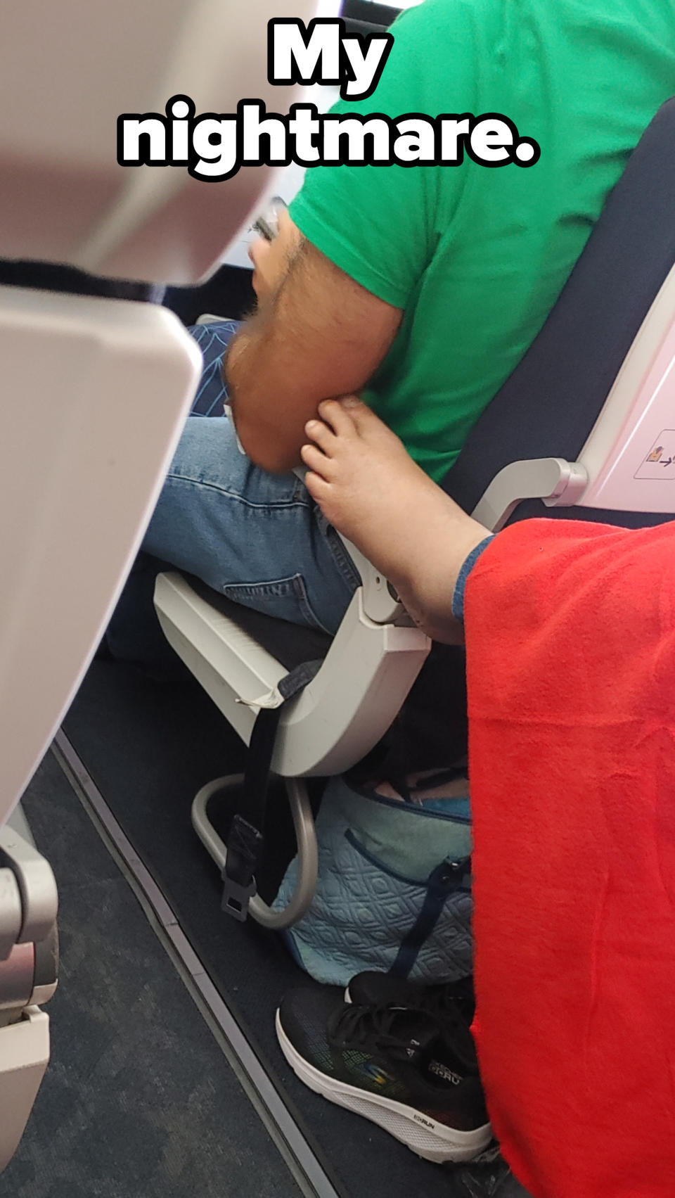 A person's foot touching someone's arm on a plane