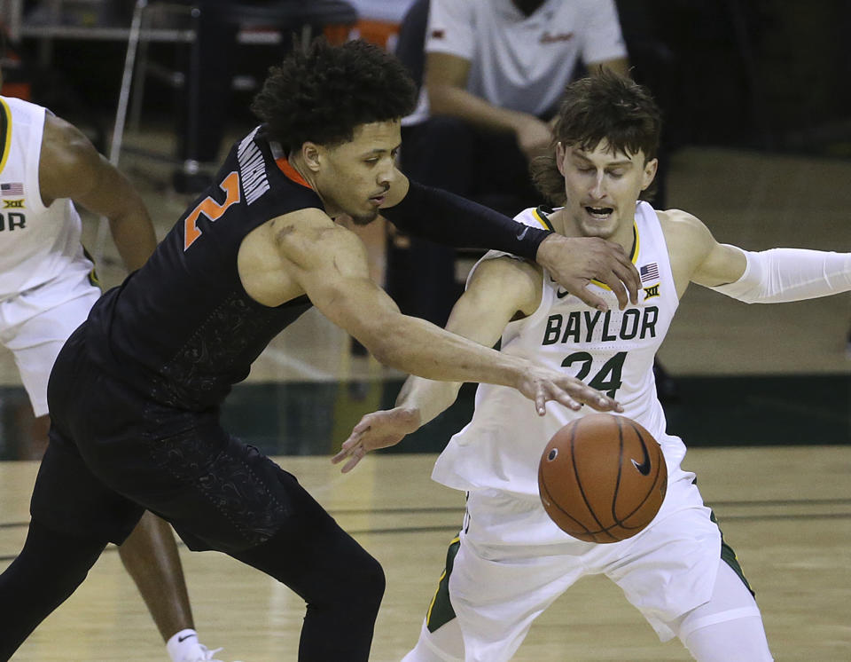 Oklahoma State guard Cade Cunningham (2) has the ball striped by Baylor guard Matthew Mayer (24) in the second half of an NCAA college basketball game, Thursday, March 4, 2021, in Waco, Texas. (AP Photo/Jerry Larson)