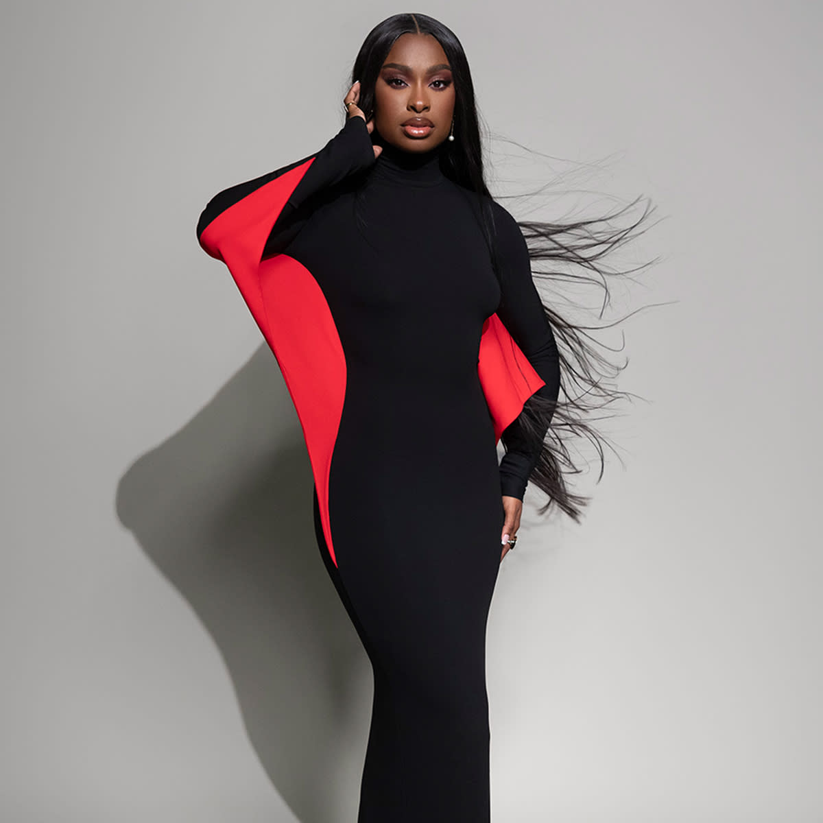  Coco jones poses in a black and red dress. 