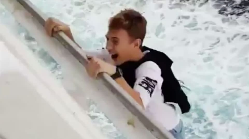 The boy laughed as he hung from the ledge of the Carnival Liberty Cruise ship. Photo: Twitter