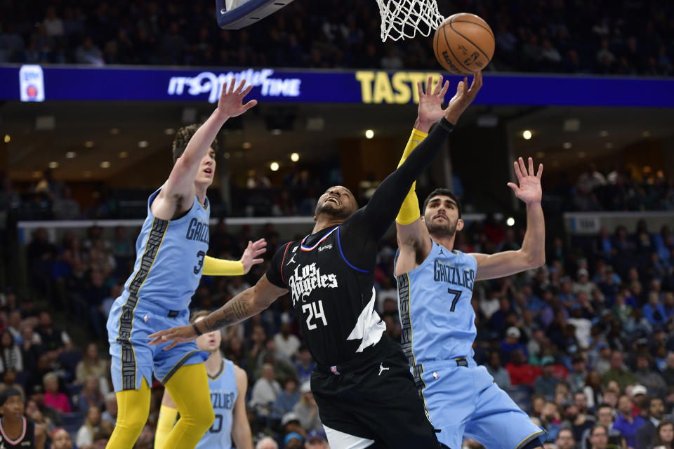 Los Angeles Clippers guard Norman Powell (24) shoots ahead of Memphis Grizzlies forwards Jake LaRavia (3) and Santi Aldama (7) in the second half of an NBA basketball game, Wednesday, March 29, 2023, in Memphis, Tenn. (AP Photo/Brandon Dill)