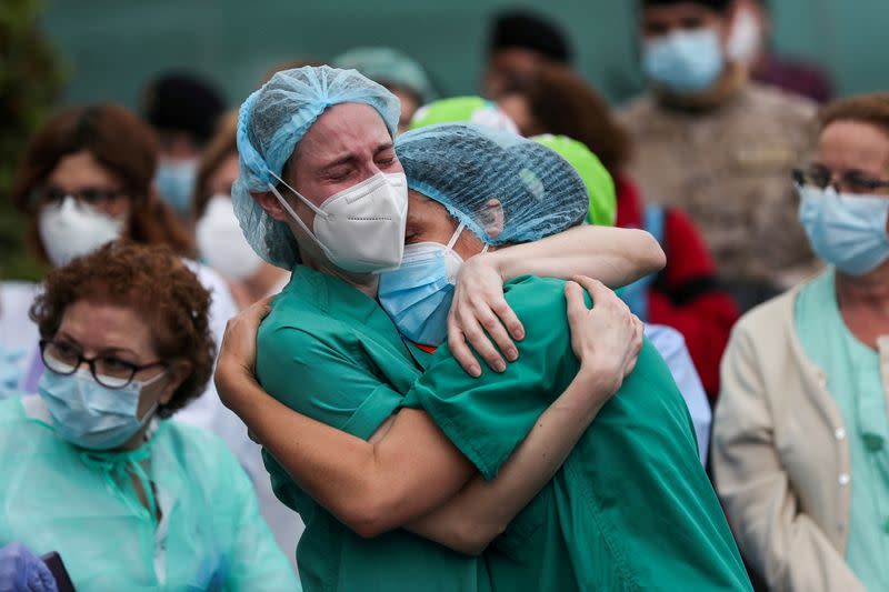 FILE PHOTO: Health workers wearing protective face masks react during a tribute for a co-worker who died in Leganes