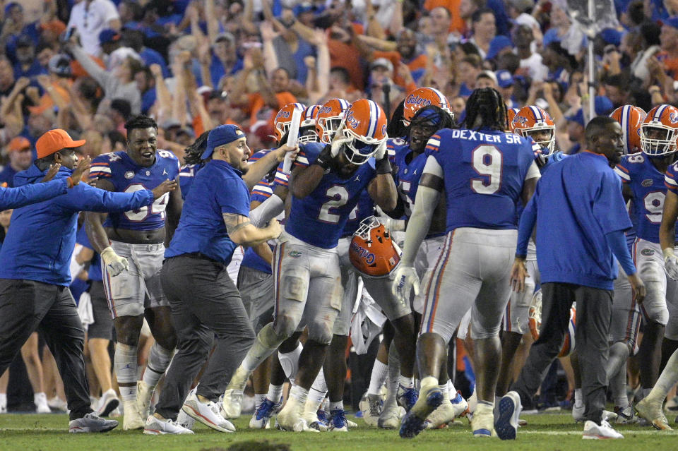 Florida linebacker Amari Burney (2) is swarmed by teammates on the sideline after making a game-saving interception in the end zone near the end of an NCAA college football game against Utah, Saturday, Sept. 3, 2022, in Gainesville, Fla. (AP Photo/Phelan M. Ebenhack)