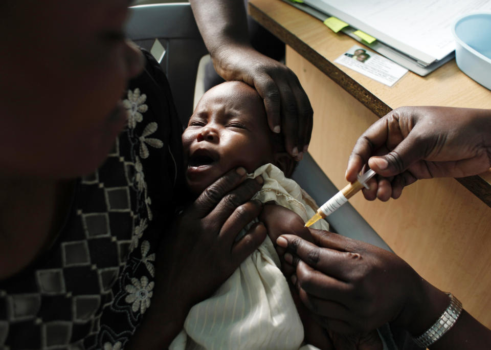 FILE - A mother holds her baby receiving a new malaria vaccine as part of a trial at the Walter Reed Project Research Center in Kombewa in Western Kenya on Oct. 30, 2009. Cameroon is beginning the world's first routine immunization program against malaria for children, a move that experts hope will mark the start of a campaign across Africa to dampen the impact of the parasitic disease. (AP Photo/Karel Prinsloo, File)