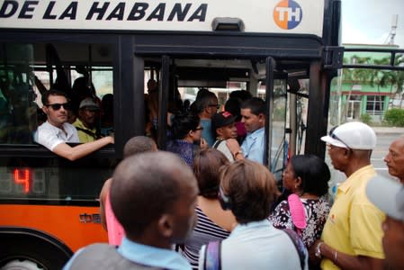 People board a public bus in Havana