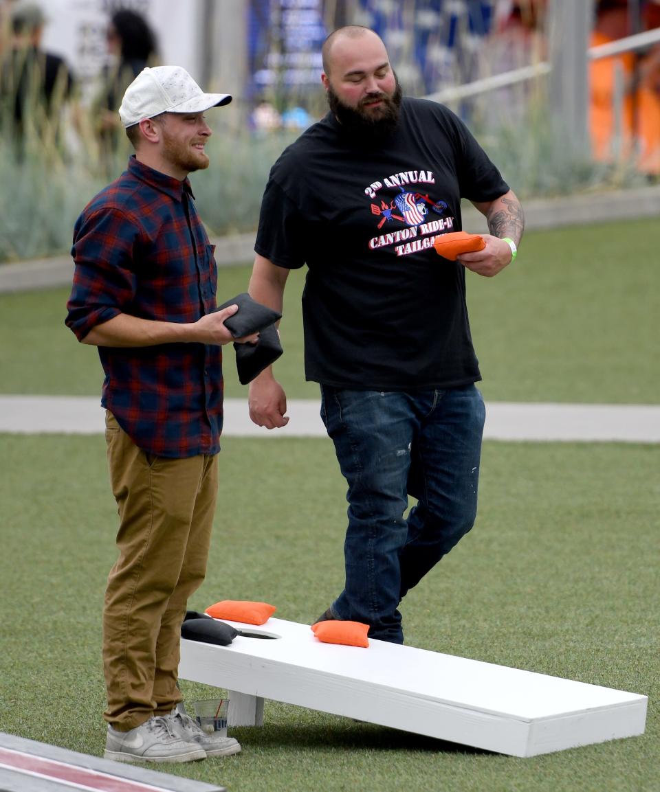 Brandon Cooper-Scharro, left, and Jacob Mathis of Streetsboro compete in a game of cornhole June 24 at the second annual Canton Ride-In Tailgate event at Canton Centennial Plaza with all proceeds going to Save22, a veteran organization to help prevent veteran suicide.