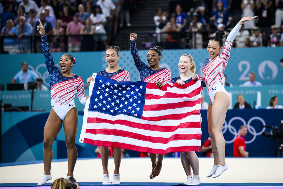 PARIS, FRANCE - JULY 30: (L-R) Jade Carey, Sunisa Lee, Simone Biles, Jordan Chiles and Hezly Rivera of Team United States celebrate winning the gold medal after the Artistic Gymnastics Women's Team Final on day four of the Olympic Games Paris 2024 at the Bercy Arena on July 30, 2024 in Paris, France. (Photo by Tom Weller/VOIGT/GettyImages)