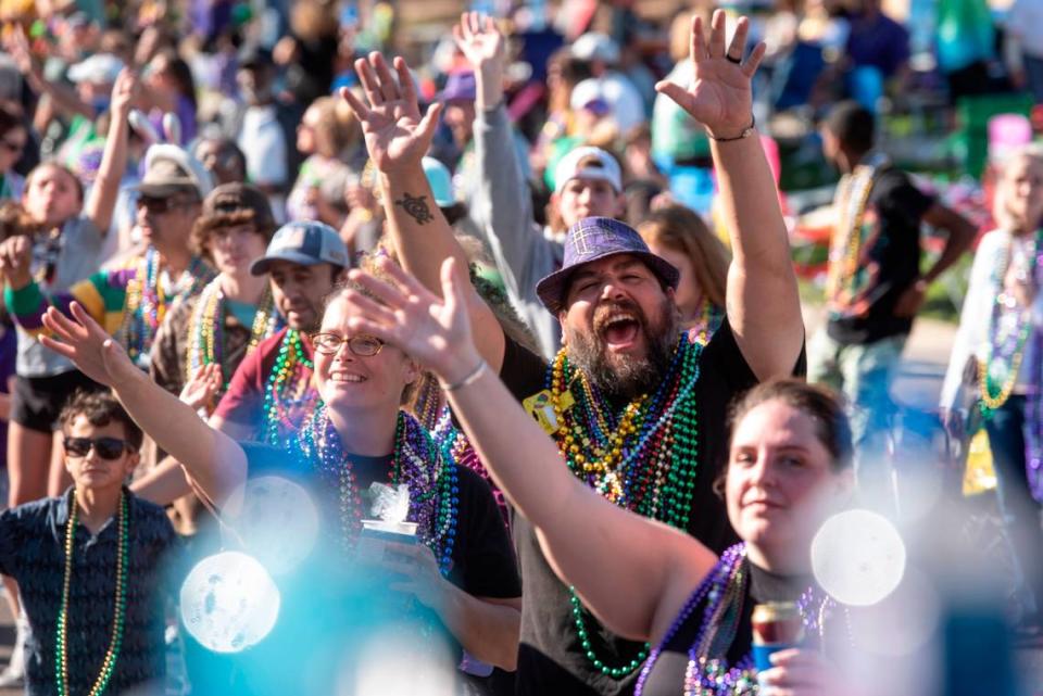 Paradegoers cheer for beads during the Gulf Coast Carnival Association Mardi Gras parade in Biloxi on Tuesday, Feb. 21, 2023.