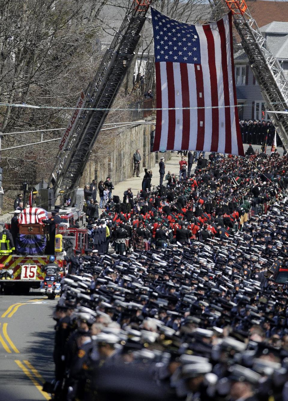 A fire truck carrying the casket of Boston firefighter Michael R. Kennedy leaves Holy Name Church in Boston, en route to the cemetery after Kennedy's funeral Thursday, April 3, 2014. Kennedy and Boston Fire Lt. Edward J. Walsh were killed Wednesday, March 26, 2014 when they were trapped in the basement of a burning brownstone during a nine-alarm blaze.(AP Photo/Stephan Savoia)