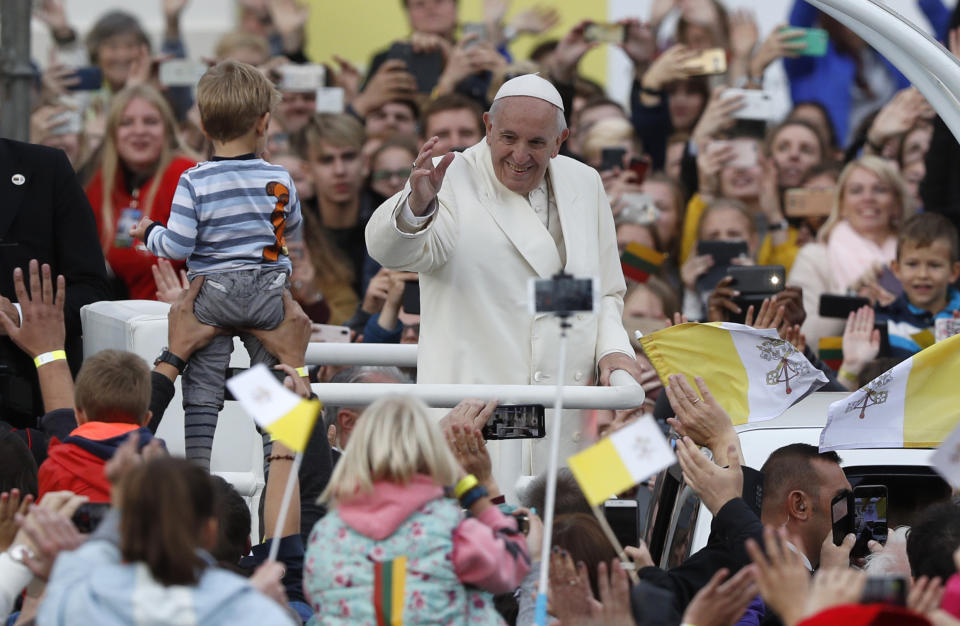 Pope Francis greets the crowd on his Popemobile as he arrives for a meeting with youths at the Cathedral Square in Vilnius, Lithuania, Saturday Sept. 22, 2018. (AP Photo/Mindaugas Kulbis)