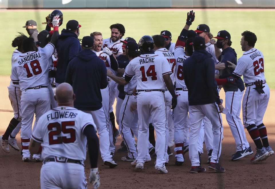 The Atlanta Braves pile on Freddie Freeman as they celebrate his game-winning RBI single to beat the Cincinnati Reds 1-0 in 13 innings in Game 1 of a National League wild-card baseball series, Wednesday, Sept. 30, 2020, in Atlanta. (Curtis Compton/Atlanta Journal-Constitution via AP)