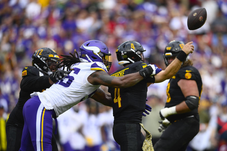 Washington Commanders quarterback Taylor Heinicke (4) gets hit from behind by Minnesota Vikings linebacker Za'Darius Smith (55) during the first half of an NFL football game, Sunday, Nov. 6, 2022, in Landover, Md. (AP Photo/Nick Wass)