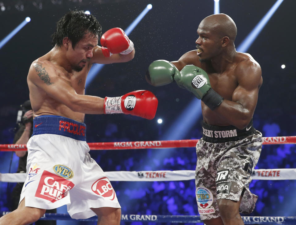 Manny Pacquiao, left, of the Philippines shields himself as Timothy Bradley throws a punch during the WBO welterweight title boxing fight Saturday, April 12, 2014, in Las Vegas. (AP Photo/Eric Jamison)