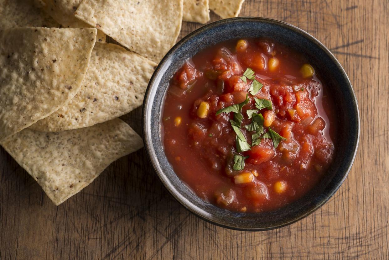 Bowl of salsa with tortilla chips on a wooden table
