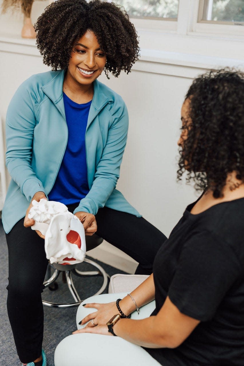 Justina Perry, left, shares the anatomy of the pelvis to a patient at Oshun Physical Therapy and Pelvic Health.