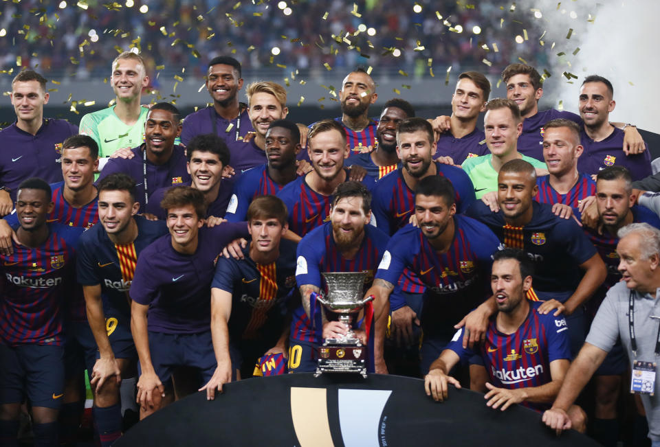 Barcelona players pose with the trophy after winning the Spanish Super Cup soccer match between Sevilla and Barcelona in Tangier, Morocco, Sunday, Aug. 12, 2018. Barcelona won 2-1. (AP Photo/Mosa'ab Elshamy)
