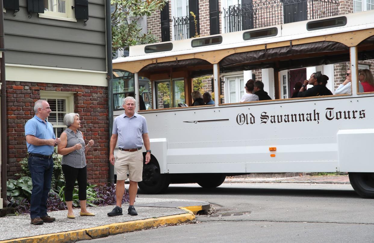 David McDonald, president of the Downtown Neighborhood Association, Nancy Radke, and Steve Mott stand on the corner of East Bryan and Houston Streets as a trolley tour passes on Wednesday, October 11, 2023.