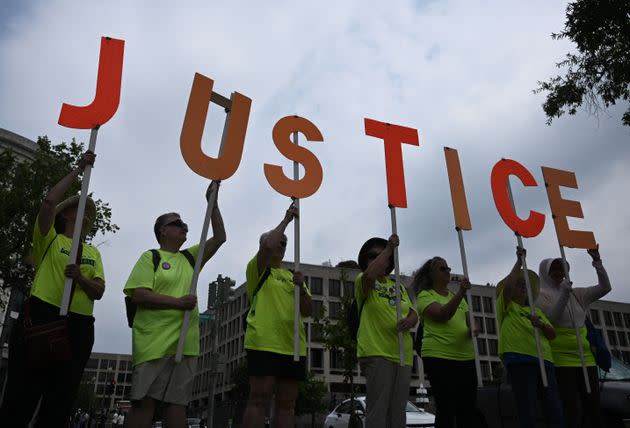 Demonstrators hold signs outside the courthouse in Washington.