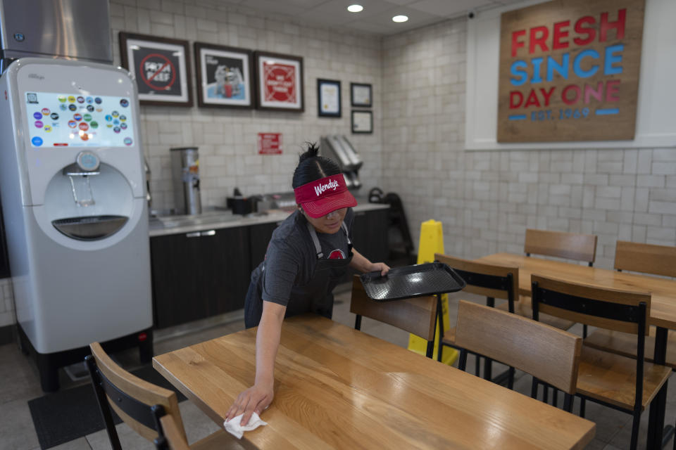 Part-time employee Adriana Ruiz, 18, cleans a table at a Wendy's restaurant owned by Lawrence Cheng and his family in Fountain Valley, Calif., Thursday, June 20, 2024. (AP Photo/Jae C. Hong)