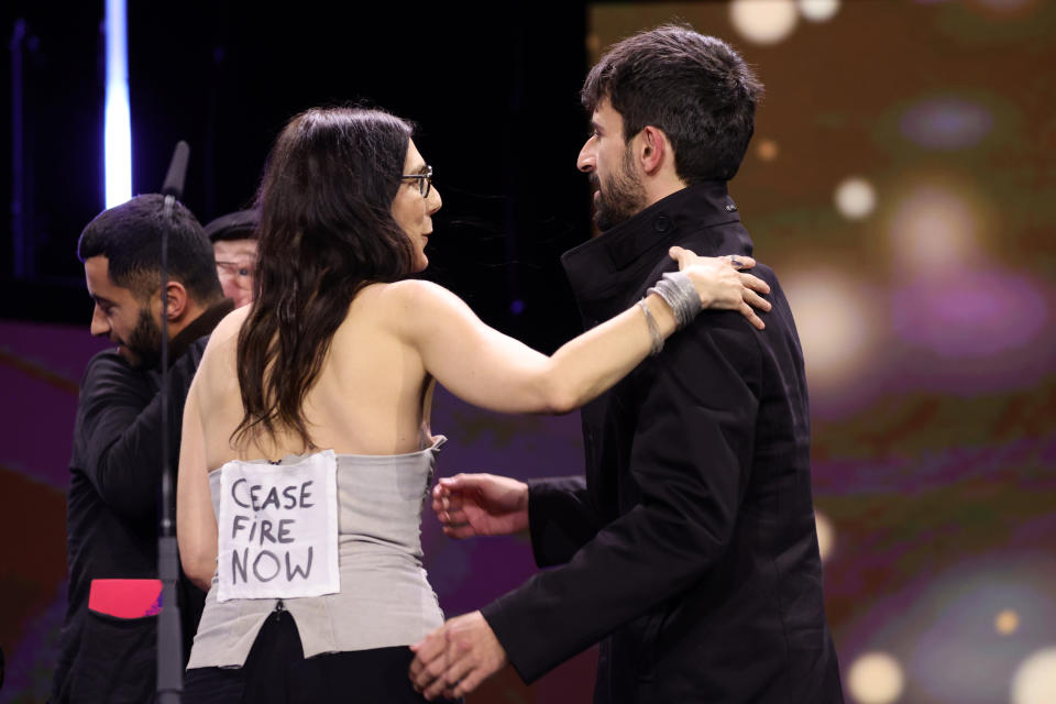 Véréna Paravel wearing 'Cease Fire Now' sign on stage for 2024 Berlinale Awards