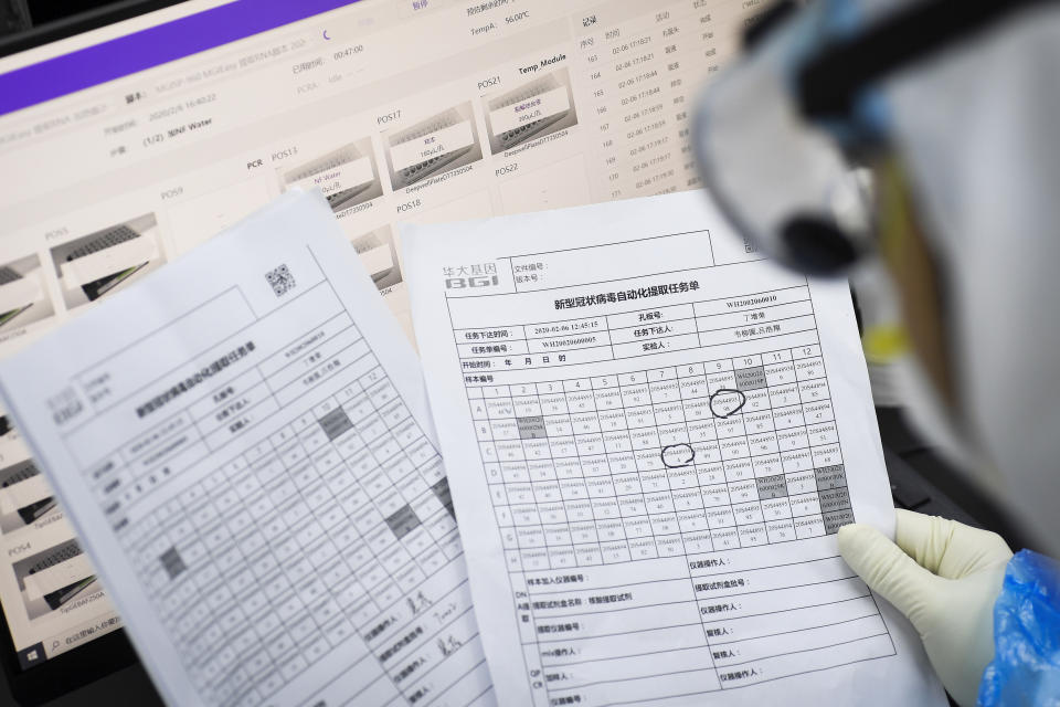 In this Thursday, Feb. 6, 2020, photo, an employee looks at lists in the pop-up Huoyan Laboratory specialized in the nucleic acid test on 2019-nCoV in Wuhan in central China's Hubei province. The coronavirus continues to spread as of Friday, Feb. 7, 2020, China reported more than 31,000 cases. (Chinatopix via AP)