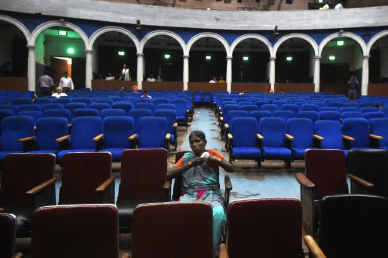 A spectator waits for a film showing at the Regal cinema in the heart of the Indian capital New Delhi