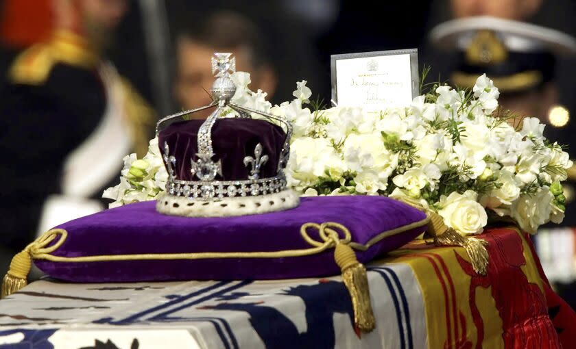 FILE - The Koh-i-noor, or "mountain of light," diamond, set in the Maltese Cross at the front of the crown made for Britain's late Queen Mother Elizabeth, is seen on her coffin, along with her personal standard, a wreath and a note from her daughter, Queen Elizabeth II, as it is drawn to London's Westminster Hall, April 5, 2002. Just hours after Queen Elizabeth II's death, Indian social media lit up with renewed calls for the return of the famous Koh-i-Noor, the 106-carat discovered in India that is part of the British crown jewels. (AP Photo/Alastair Grant, File)