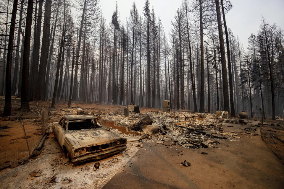 A vehicle and property were destroyed by the Caldor Fire sit in Grizzly Flats, Calif., on Tuesday, Aug. 17, 2021. A father and son have been arrested on suspicion of starting a massive California wildfire that forced tens of thousands to flee the Lake Tahoe area earlier this year, officials said Wednesday, Dec. 8, 2021. The El Dorado County District Attorney’s office said in a statement that David Scott Smith and his son, Travis Shane Smith, are accused of reckless arson in a warrant issued before formal charges are filed. (AP Photo/Ethan Swope, File)