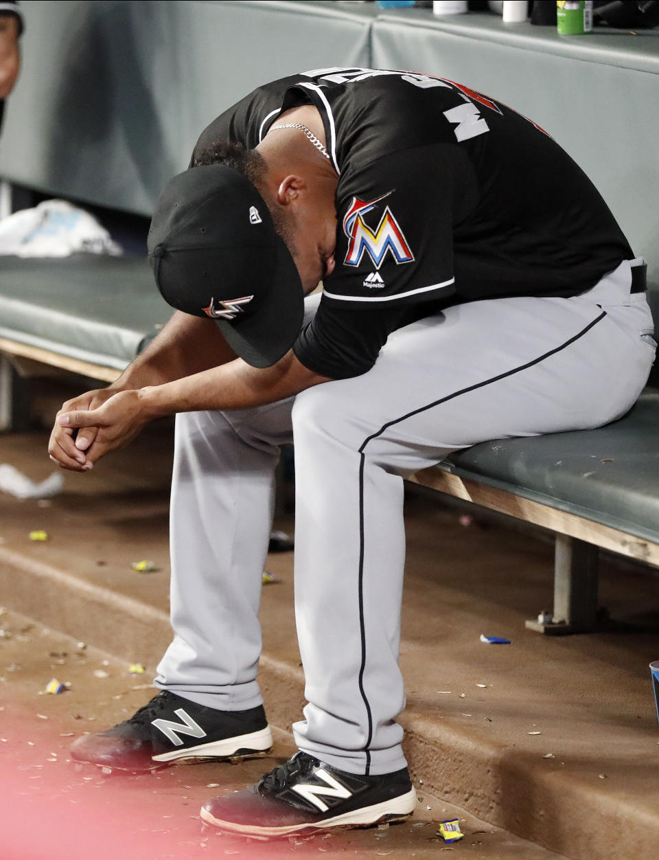 Miami Marlins starting pitcher Merandy Gonzalez (77) sits on the bench after being relieved in the fifth inning of the second baseball game of a doubleheader against the Atlanta Braves Monday, Aug. 13, 2018 in Atlanta. (AP Photo/John Bazemore)