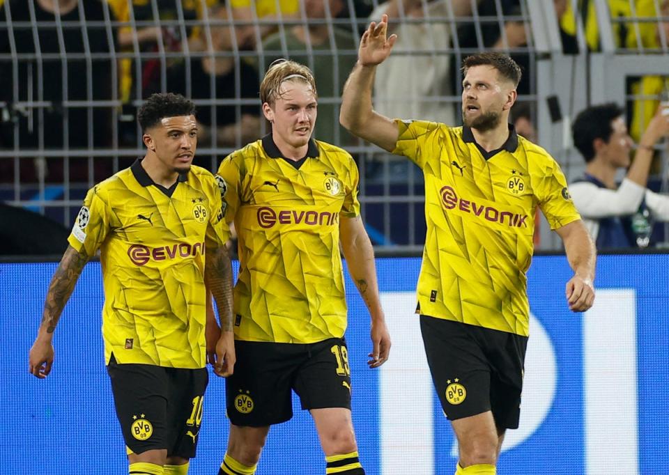 Jadon Sancho, left, Julian Brandt, centre, and Niclas Fullkrug, right, celebrate the win for Dortmund  (AFP)