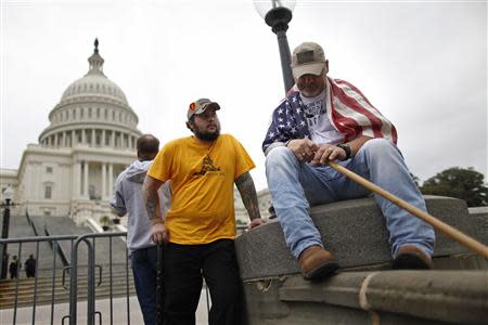 U.S. Army veterans Peter Marshall Bland (C) and James Taylor (R) of Fort Hood, Texas, end a day of protest with a group from the "Million Vet March on the Memorials", rallying against the closure of the U.S. National World War Two Memorial due to the current U.S. government shutdown, on the west front of the U.S. Capitol in Washington, October 13, 2013. REUTERS/Jonathan Ernst