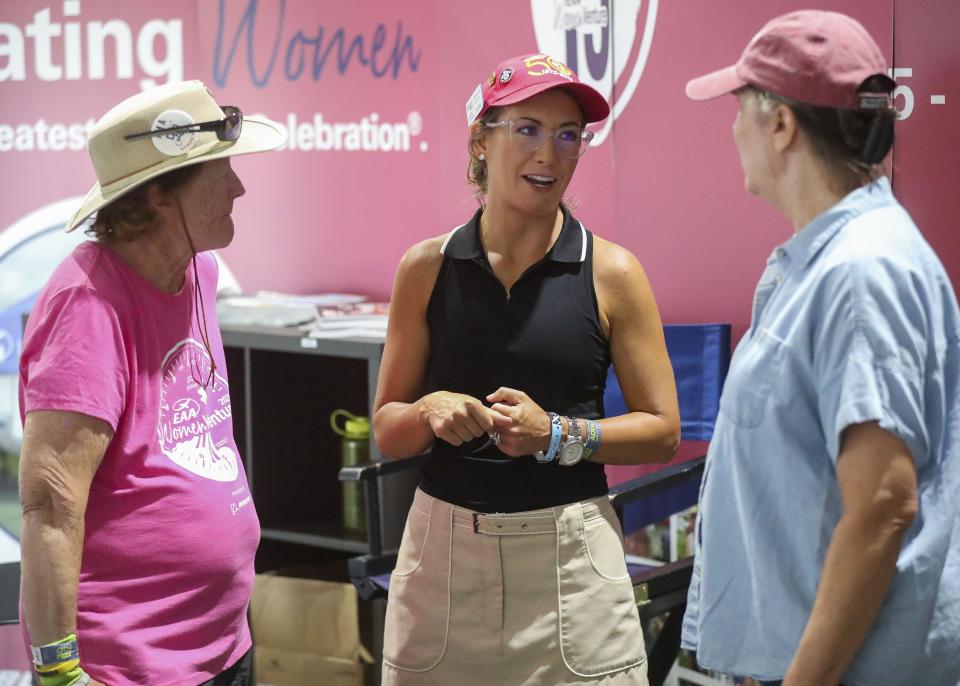 Oshkosh native Margaret Viola, center, talks with Billie Lenz, left, and Olivia Jones, right Thursday inside WomenVenture's new exhibit hall during Day 4 of EAA AirVenture at Wittman Regional Airport in Oshkosh. Viola started working for EAA selling T-shirts at 14 years old and now chairs WomenVenture.