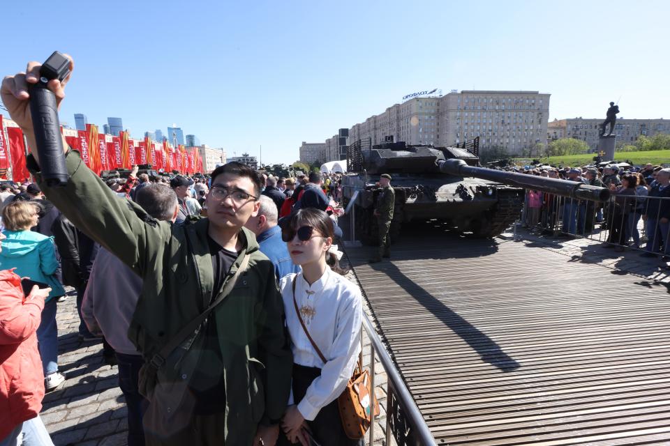 Visitors take a selfie at the "Trophies of the Russian Army" open-air exhibition, which paraded an array of Western-made military hardware captured by Russian troops.
