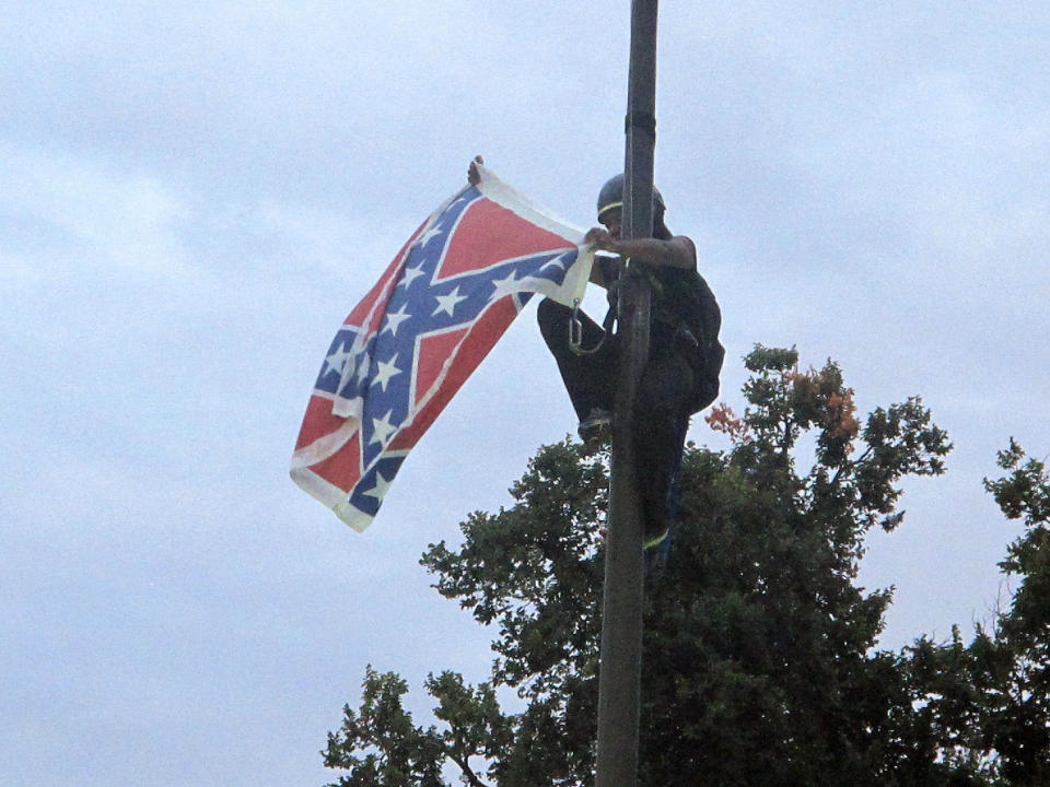 Bree Newsome of Charlotte, N.C., removes the Confederate battle flag at a Confederate monument at the Statehouse in Columbia, S.C., on Saturday, June, 27, 2015. 