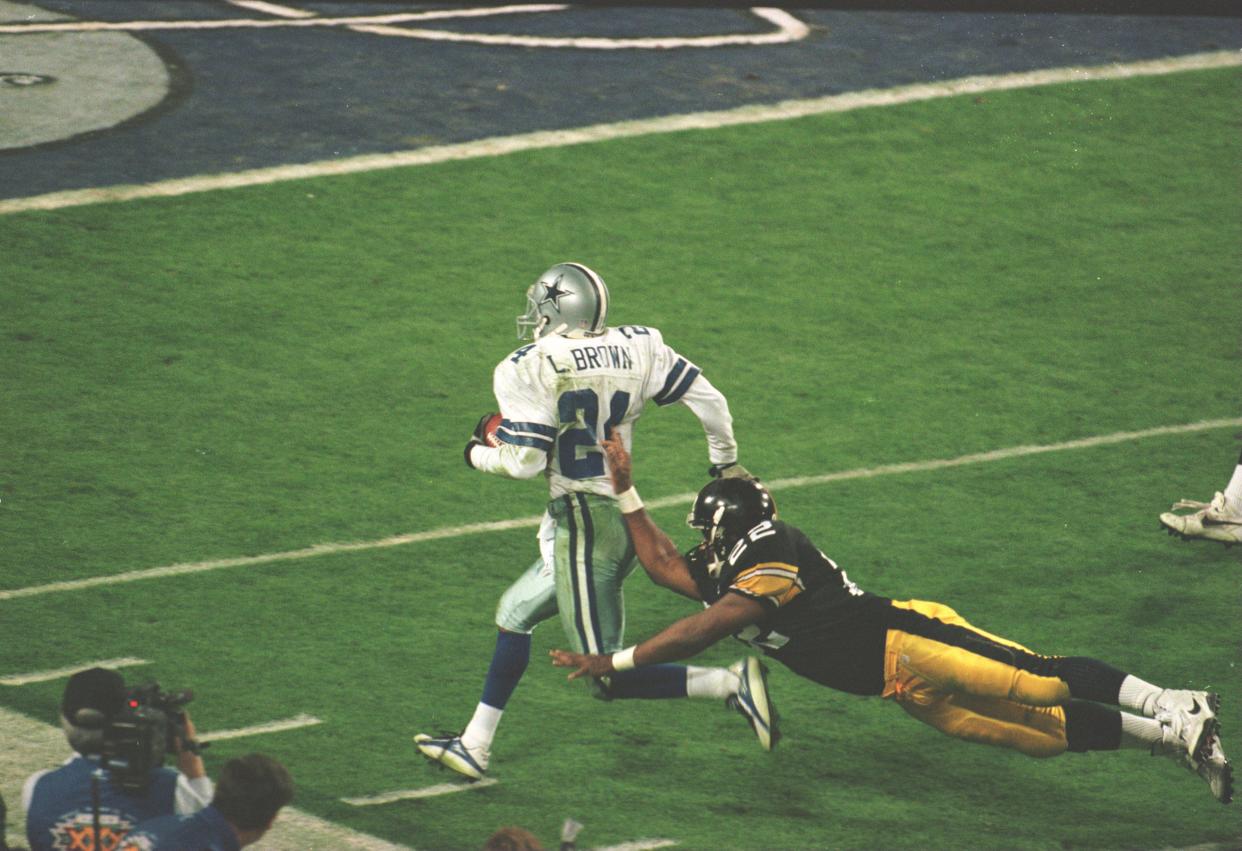 Cornerback Larry Brown of the Dallas Cowboys is pushed out of bounds by running back John L. Williams of the Pittsburgh Steelers during the 4th quarter of the Cowboys game versus the Steelers in Super Bowl XXX.