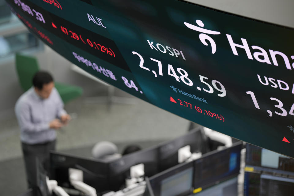 A currency trader stands near the screen showing the Korea Composite Stock Price Index (KOSPI) at a foreign exchange dealing room in Seoul, South Korea, Friday, March 29, 2024. Asian shares were mostly higher Friday in quiet holiday trading, with markets closed in Hong Kong, Sydney, Singapore and India, among other places. (AP Photo/Lee Jin-man)